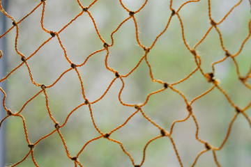 Fototapeta premium Rope netting on blurred natural background. Selective focus. Copy space. Minimalism.