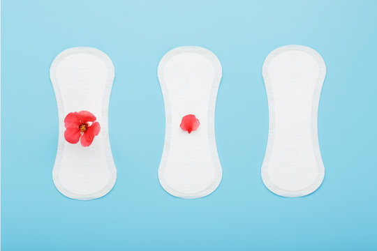 Women's Sanitary Pads On A Blue Background. The Concept Of Critical Days, Menstrual Cycles In Several Stages.