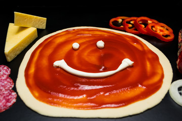 Dough base with ketchup and pizza ingredients