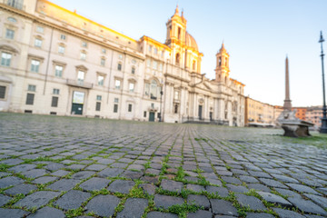 Fototapeta na wymiar Piazza Navona in Rome appears like a ghost city during the covid emergency lock down, grass on the floor