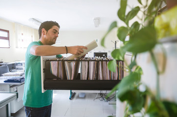 Office worker in office looking in drawer files