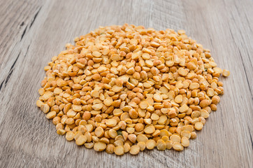 yellow peas on a wooden background.