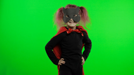 Funny child girl in costume and mask plays super hero. National superhero day