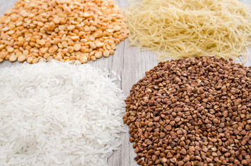 buckwheat, rice, peas and pasta on a wooden background. Close-up. Various cereals and legumes.