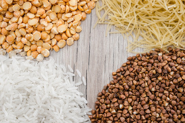 buckwheat, rice, peas and pasta on a wooden background. Close-up. Various cereals and legumes.