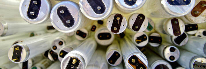 large amount of spent old fluorescent lamp tubes about to be recycled. Waste Disposal concept for old fluorescent lamp tubes. Ecology background or texture concept. Scrap yard scenery.