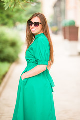 Young woman in green dress in the city walks