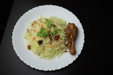 Chicken Biryani showing leg piece - It's a delicious recipe of Basmati rice mixed with with spicy marinated chicken in a bowl.  Served in a bowl or plate. Selective focus