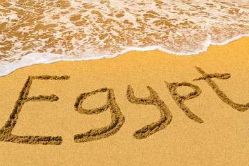 Egypt title on the sand beach of the Red sea. Hot season. Wave.
