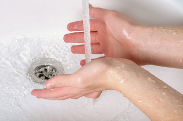 Wash hands with soap and tap water in bathroom as protection against bacteria, flu and dirt for skin health