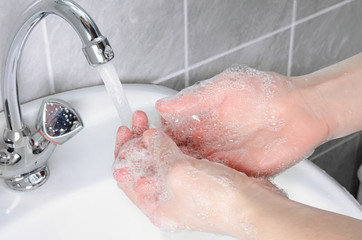 Cleaning hands from dirt, bacteria and viruses with tap water in the bathroom to protect against flu and illness