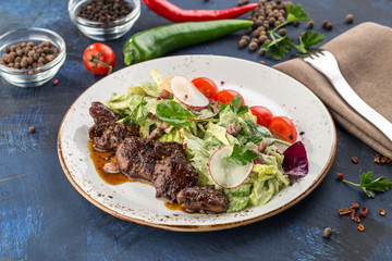 Salad with Chicken Liver, lettuce and beans on blue background