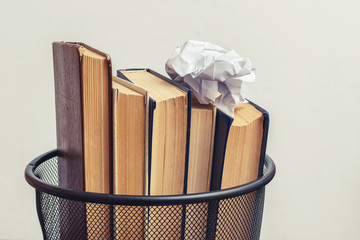 Books and crumpled paper in the bin. Books that do not read, low-grade literature