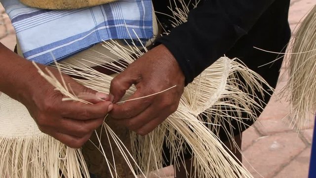 People weaving panama hats close up 