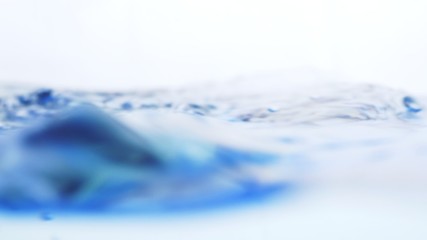 Soft blur focus of Abstract water splash surface filling the frame with the water drop and waving liquid with an air bubble on a white background and copy space.