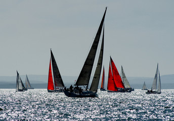 Red sails and yachts sailing in the round the island race off The Isle of Wight