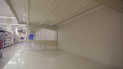 Shopper During Corona Virus Outbreak Passes Empty Shelves From Consumer Panic