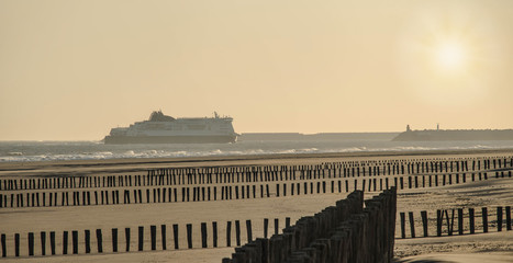 beautiful landscape with a ferry arriving in the port of Calais at dawn