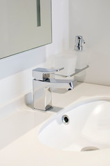 New stainless steel faucet In bathroom. Vertical photograph.