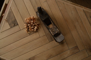 Stary strug ręczny na tle dębowego drewna. 
Old manual plane on the background of oak wood. - obrazy, fototapety, plakaty