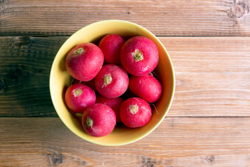 Yellow plate with radish on a wooden table
