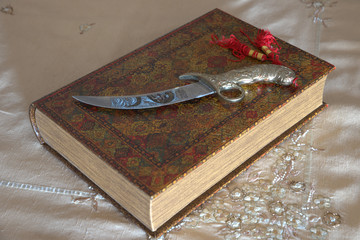 
Arabic knife in Indian tablecloth and leather book