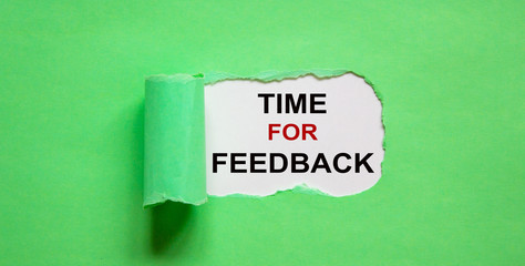 The text 'time for feedback' appearing behind torn green paper.
