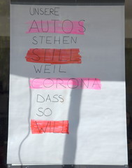 Plakat im Fenster einer Fahrschule: "Unsere Autos stehen still, weil Corona das so will."