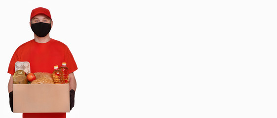 Valanter in protective gloves and a mask holds a box on a light background. Donation concept. Voluntary assistance to those in need.Сoncept goods in virus or coronavirus quarantine. 