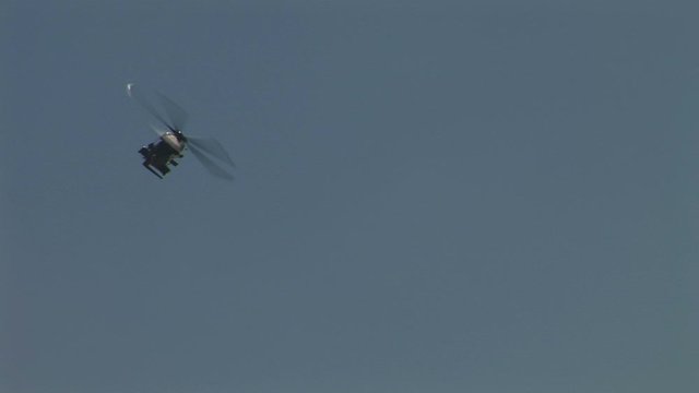 Military helicopter flying in blue sky close up UK 4K