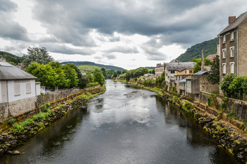 Fototapeta na wymiar View of the river Dordogne at Bort les Orgues, a little french village in Correze, Auvergne. The beauty of the river in a very cloudy day.