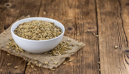 Portion of healthy Oat on an old wooden table (selective focus; close-up shot)