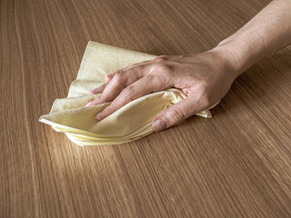 hand with wet wipe cleaning table