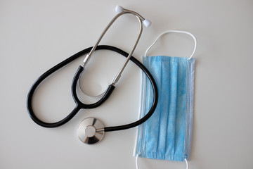 Masks and stethoscope on white background