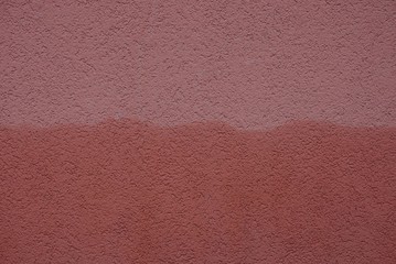 dark red brown stone texture of wet stucco on concrete foundation wall