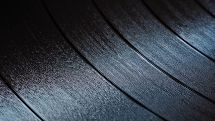 Black vinyl record with recorded music, close-up.