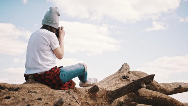 Young hipster woman using vintage camera to photograph landscape. Slow motion shot