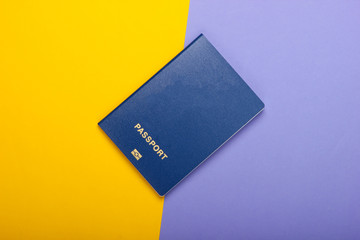 Tourism and travel concept. Emigration. Passport on purple yellow background. Top view. Flat lay