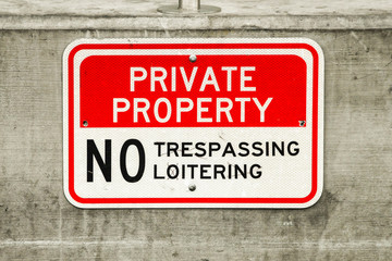 Close up view of a "Private property - No Trespassing or Loitering" sign