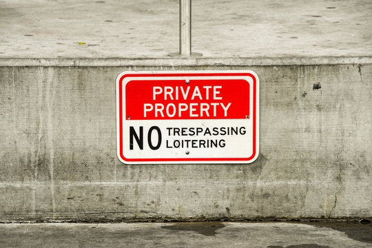 Close up view of a "Private property - No Trespassing or Loitering" sign