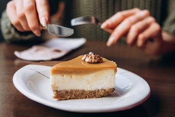 cutlery over a piece of nut cheesecake, the moment you try to taste a delicious cake