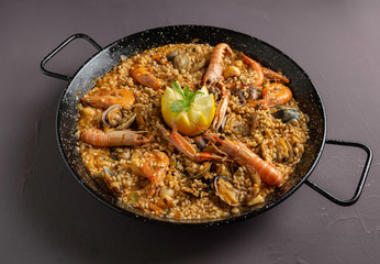 Spanish seafood paella with rustic dark background