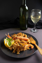 Spanish seafood paella on black plate