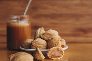 cookie in the form of walnuts stuffed with condensed milk on a wooden background with place for your text