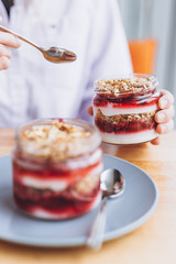jar dessert: granola with dried fruits and cherry jam, modern dessert in natural ingredients in a cozy cafe