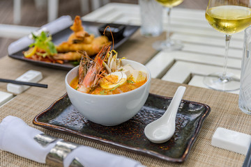 Tasty tom yum soup with shrimps served on table in restoraunt
