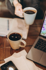 freelancer workflow at a coffee table, people have coffee, chat, work on a computer and use the phone