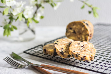 Sherbet, cookies with fondant, nuts and raisins on a wire rack on a light gray background in the background flowering branch horizontal arrangement