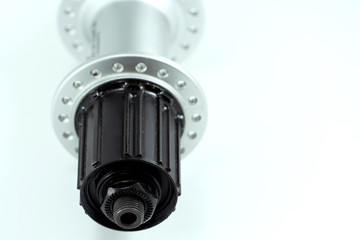 Bicycle repair. Mountain bike workshop. Rear hub under the disc brake on a white background. The body is silver. Spare parts for a bicycle of a famous manufacturer and brand.