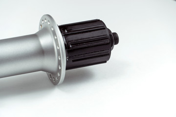 Bicycle repair. Mountain bike workshop. Rear hub under the disc brake on a white background. The body is silver. Spare parts for a bicycle of a famous manufacturer and brand.